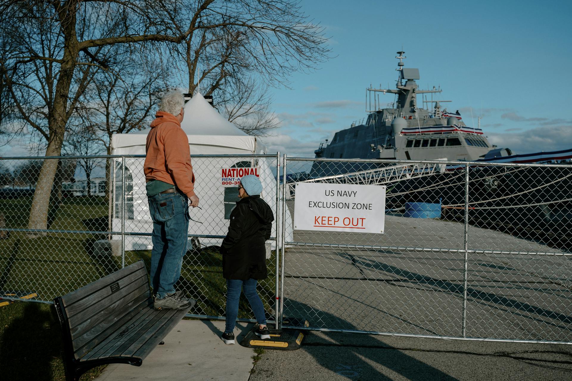 People observe US Navy ship behind an exclusion fence in Milwaukee, Wisconsin.