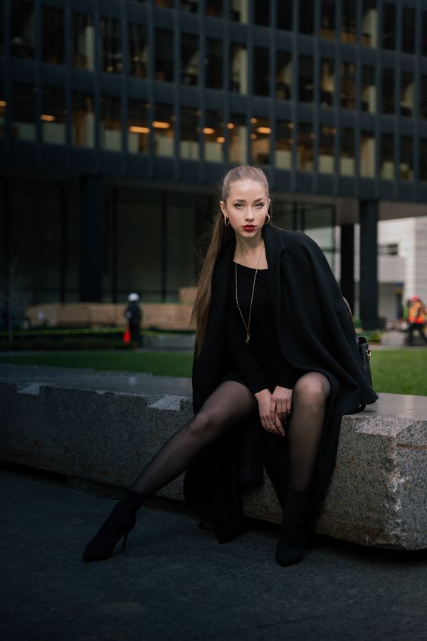 Woman in black wool cape coat over evening gown