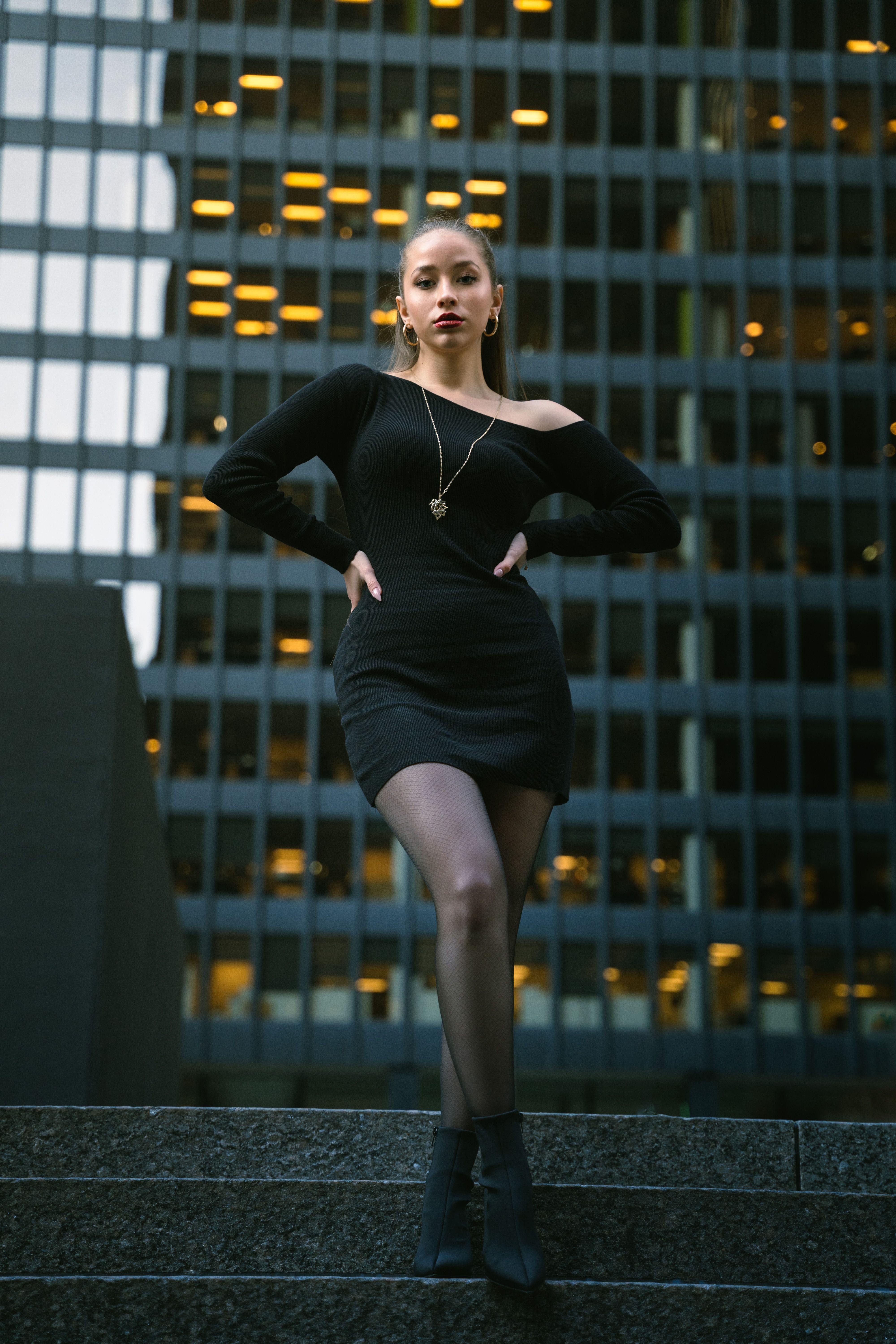 Elegant Woman Posing in Urban Setting at Twilight · Free Stock Photo