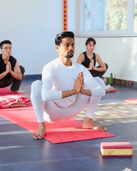 A diverse group of people practicing yoga and meditation indoors with focused concentration.