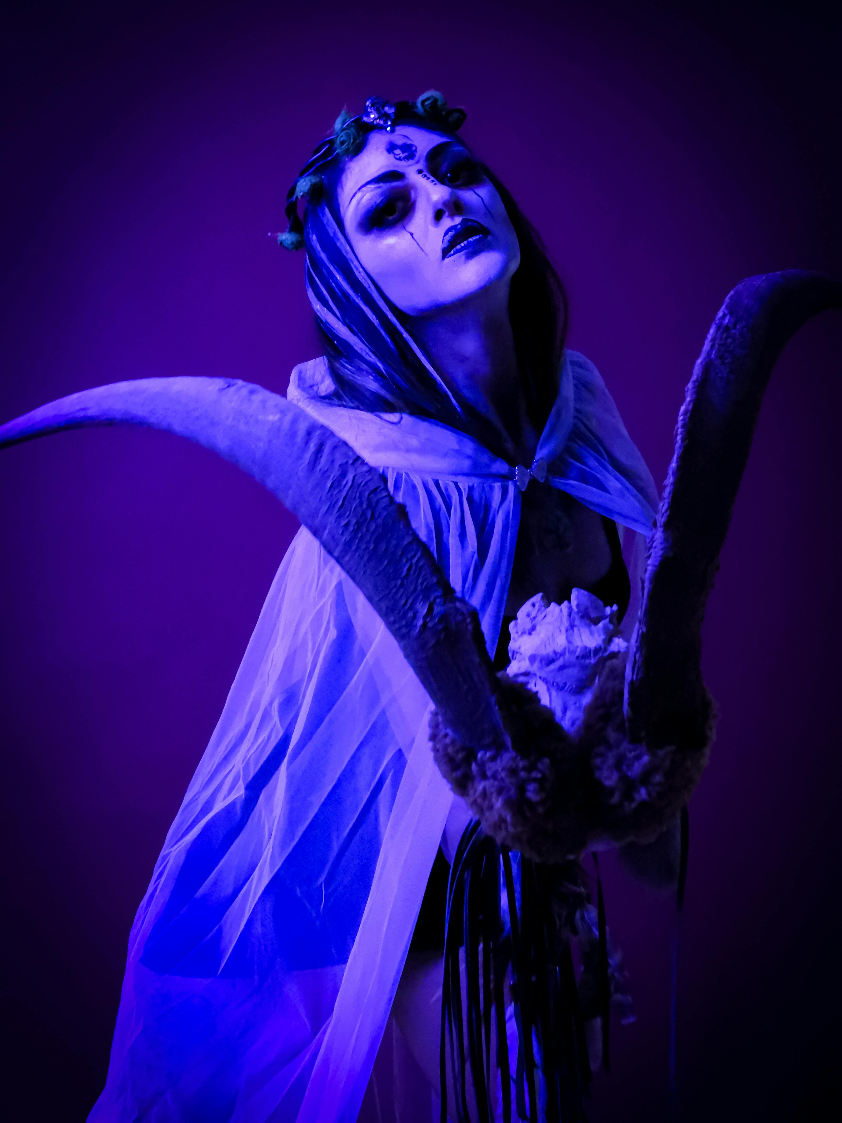 grátis Uma bruxa mística e etérea com chifres, capturada em um retrato artístico em tons de azul. Foto profissional