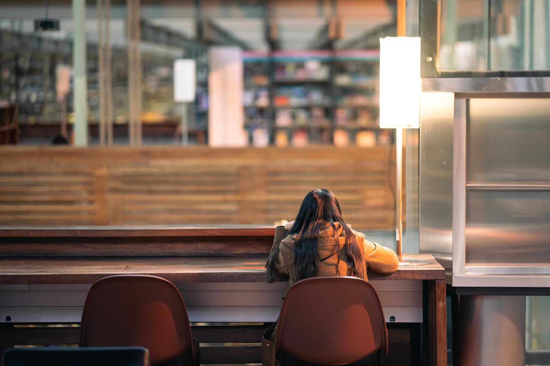 Young adult studying alone at a table in a modern library setting in Mexico City.