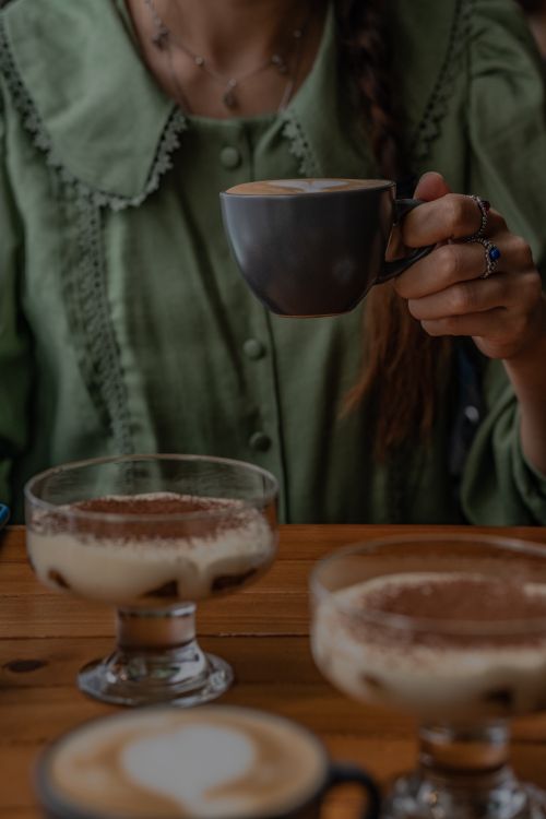 Free A woman drinks coffee while seated at a table with desserts in Azerbaijan. Stock Photo