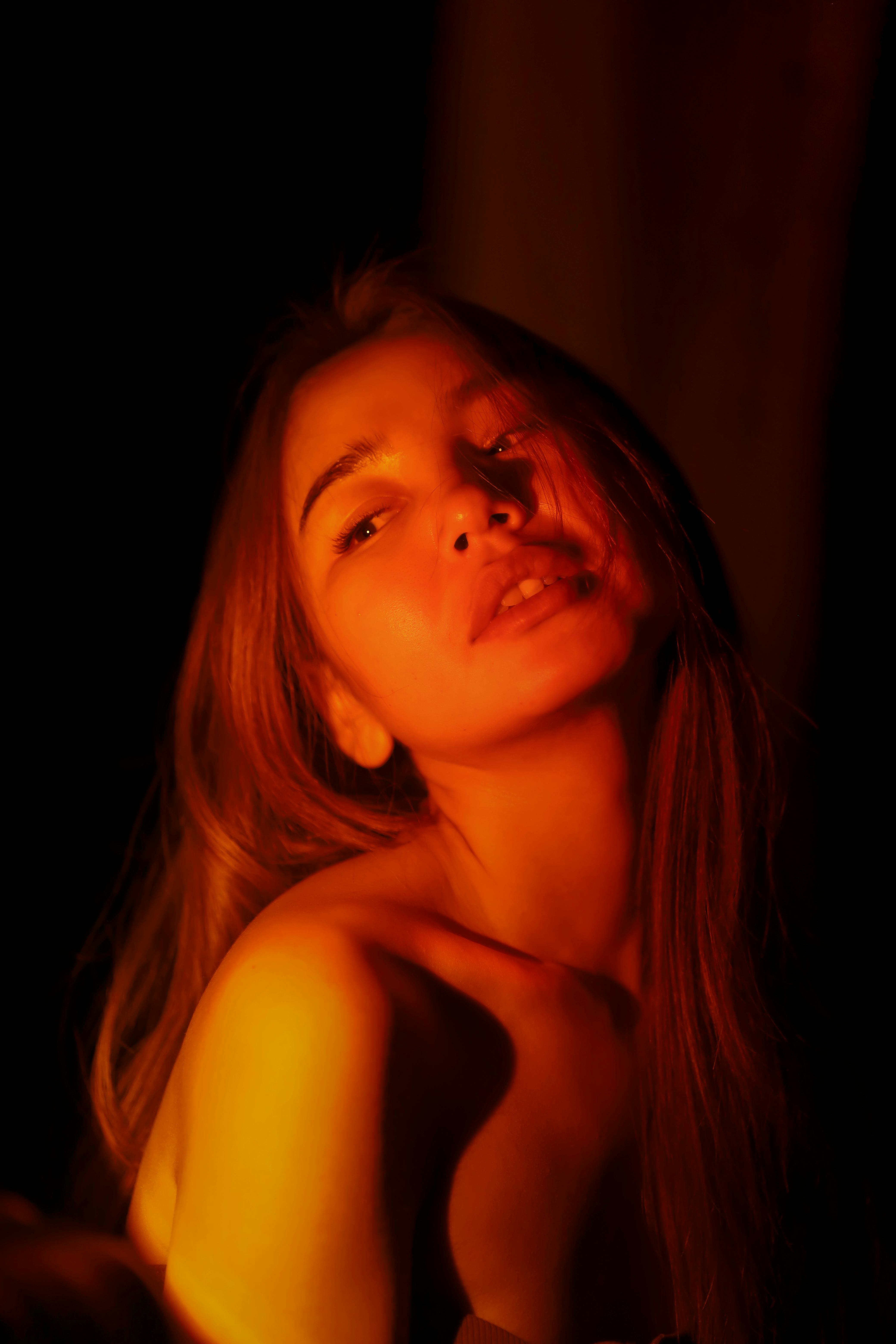 Elegant portrait of a woman bathed in warm, dramatic lighting.