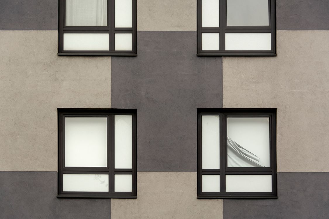 Modern Building Facade with Geometric Windows · Free Stock Photo