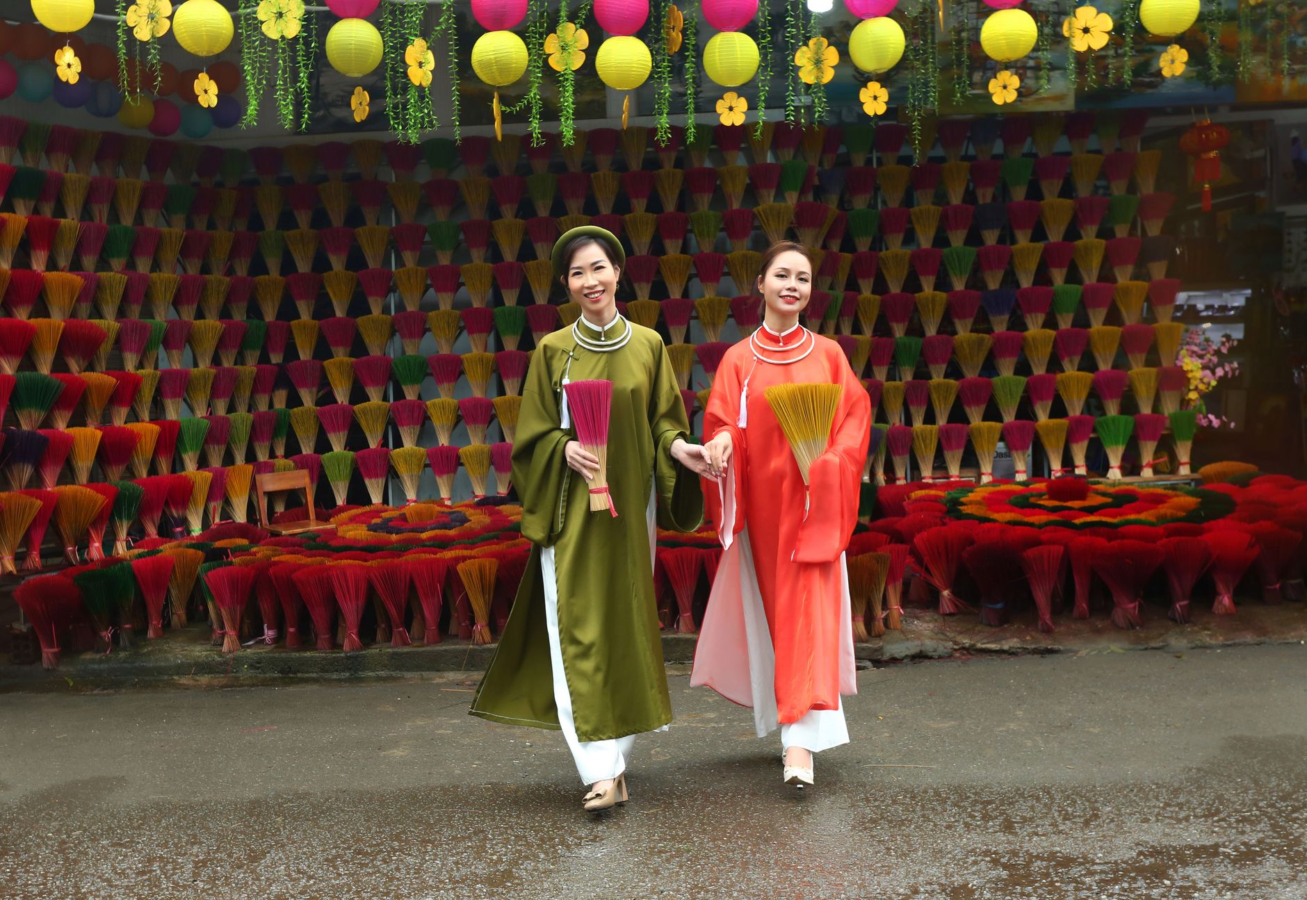 A traditional Vietnamese village festival with spectators observing a rooster display beside an old communal house