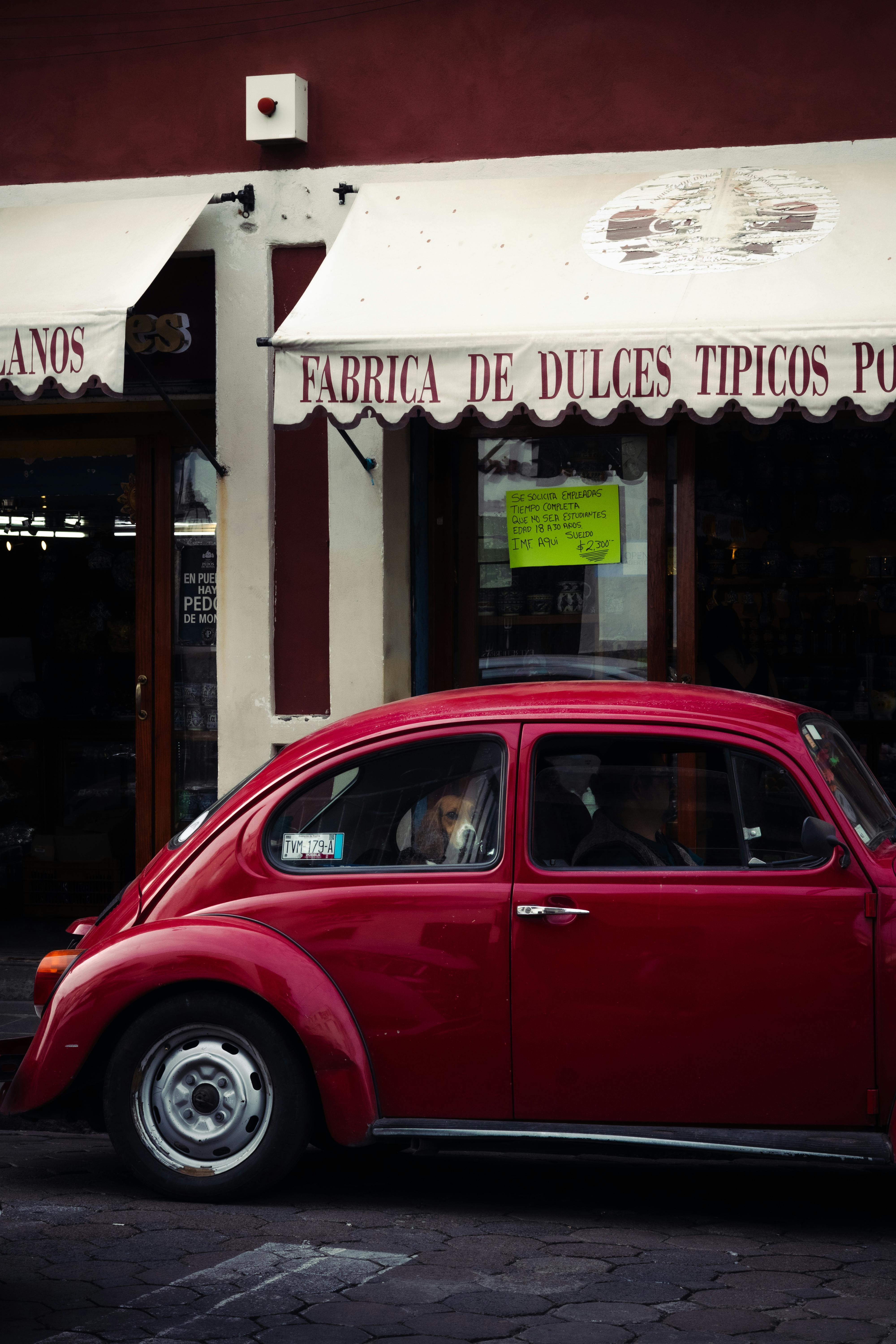 red vintage beetle in front of mexican confectionery