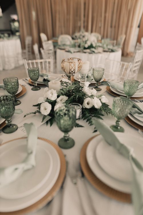 Free Beautifully decorated wedding reception table with floral centerpiece and green glassware. Stock Photo