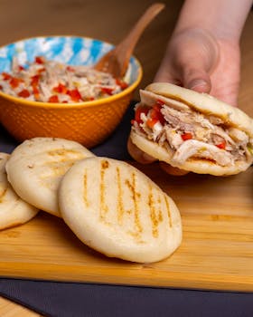 A fresh arepa filled with chicken and peppers, ready to eat.