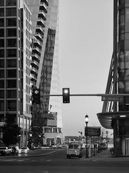 Monochrome street scene featuring modern skyscrapers and traffic lights.
