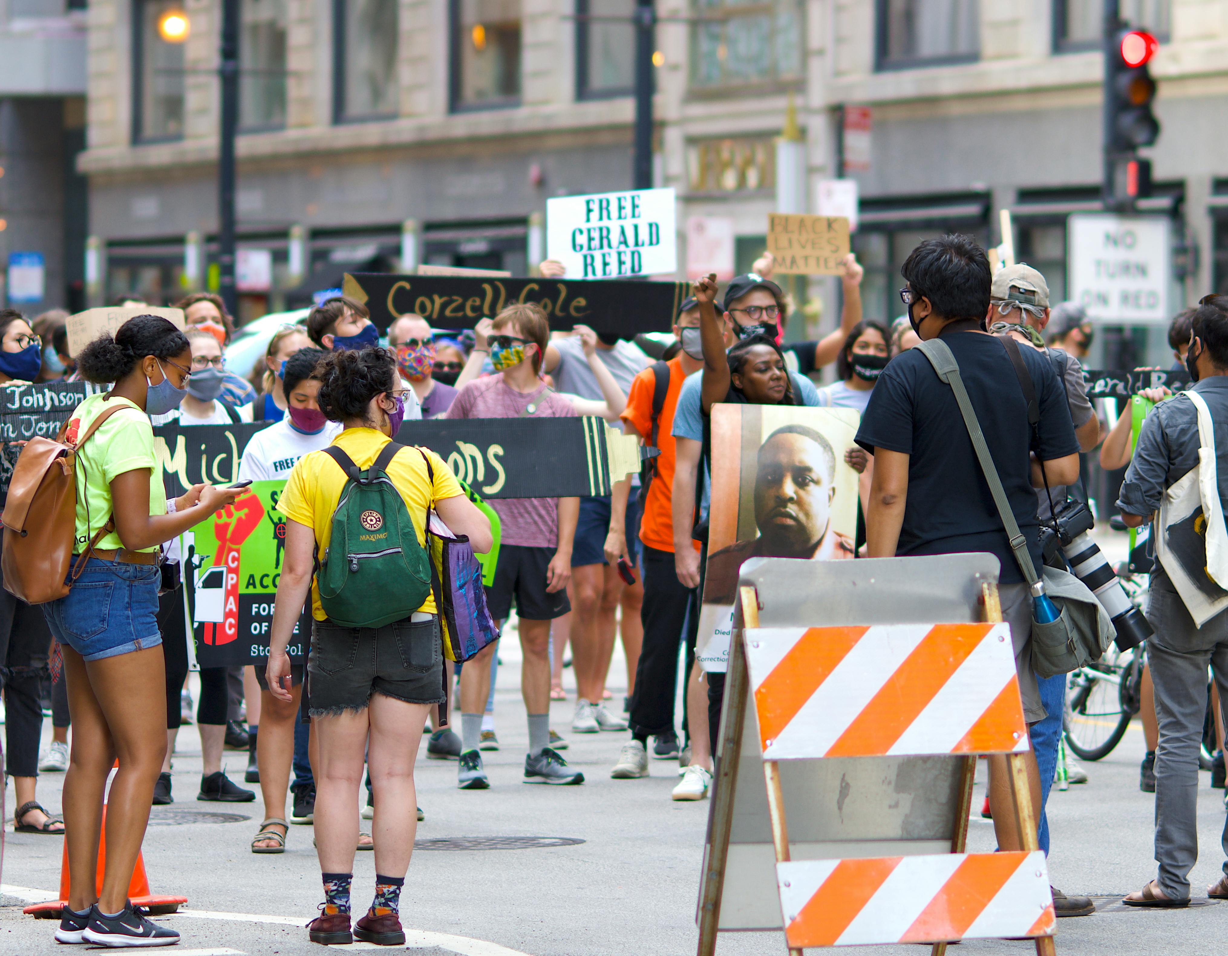 A diverse group of protesters gather peacefully in a city, advocating for justice reform.