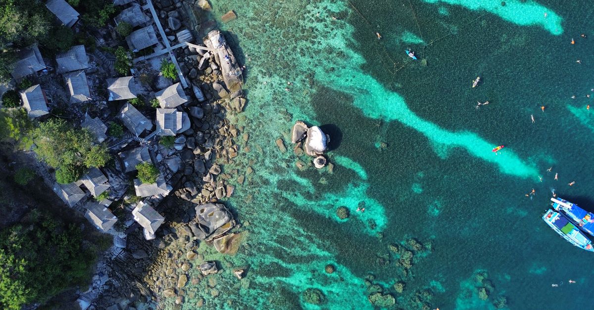Explore the stunning coastline and clear waters of Ko Tao, Thailand from above.