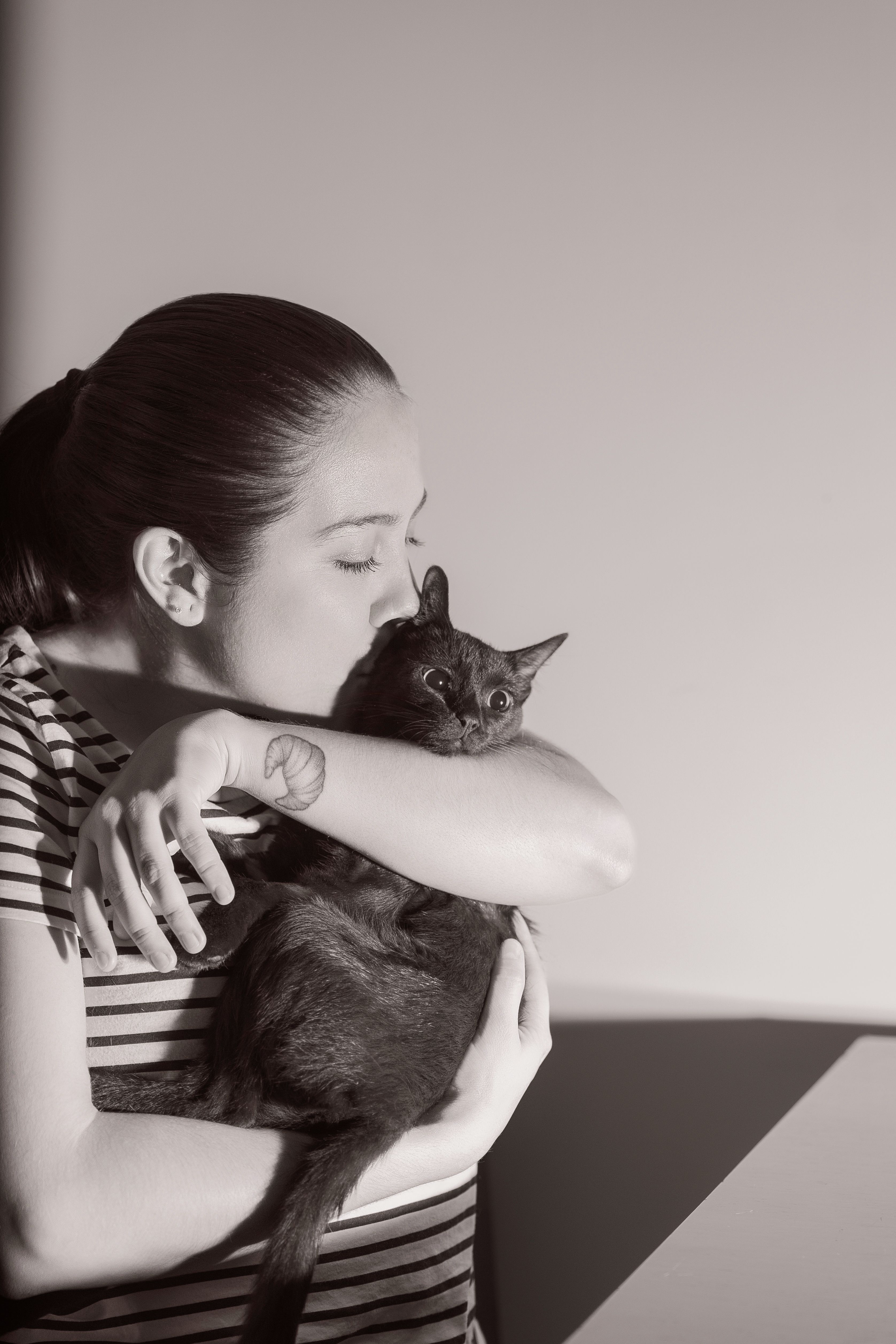 A loving moment between a woman and her cat indoors, captured in Heredia.