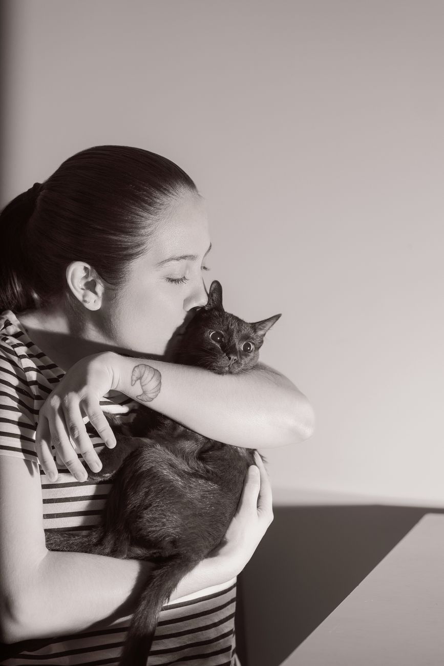 A loving moment between a woman and her cat indoors, captured in Heredia.