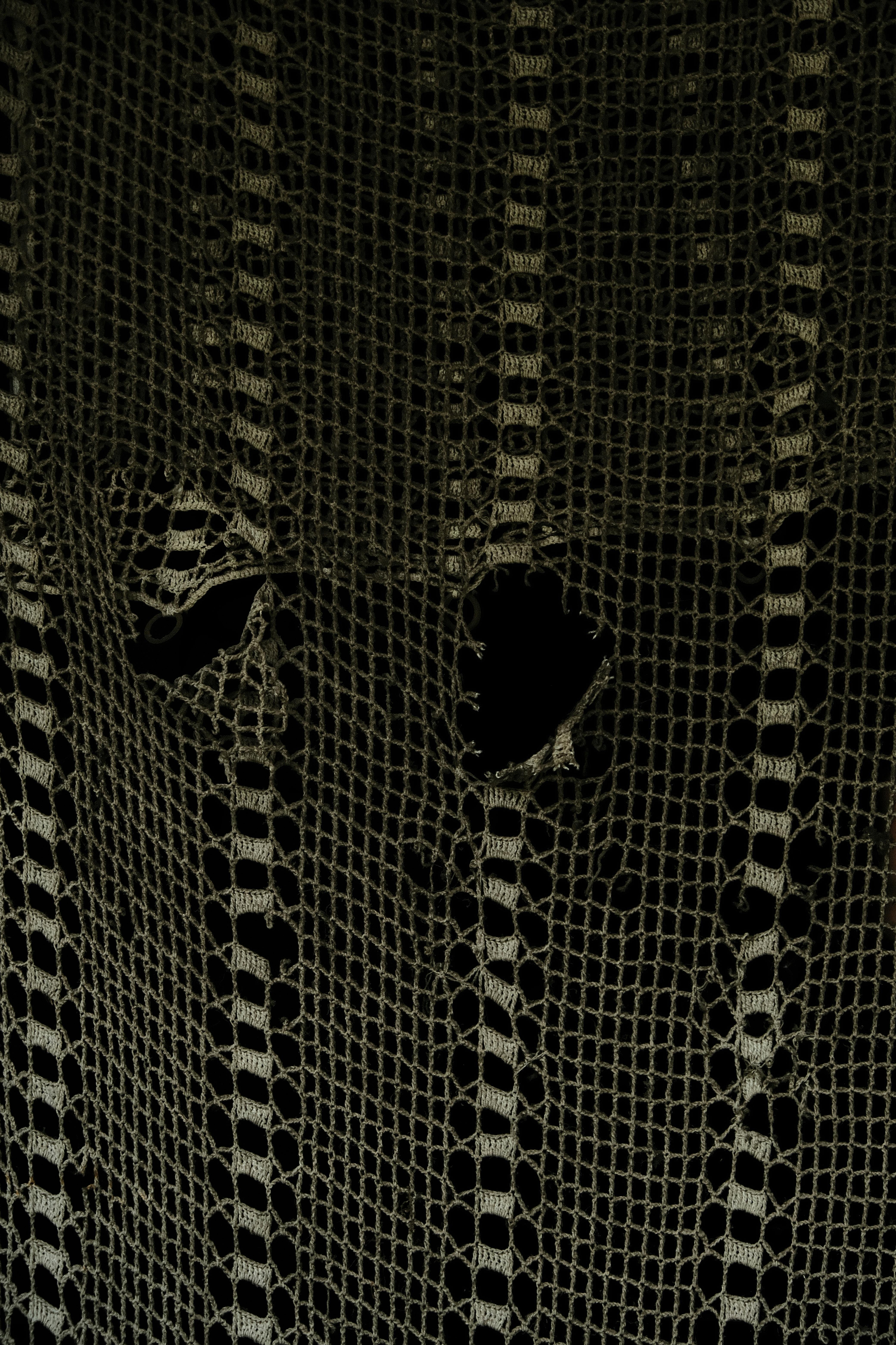 Close-up of vintage crochet lace fabric showcasing intricate patterns and texture.