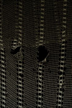 Close-up of vintage crochet lace fabric showcasing intricate patterns and texture.