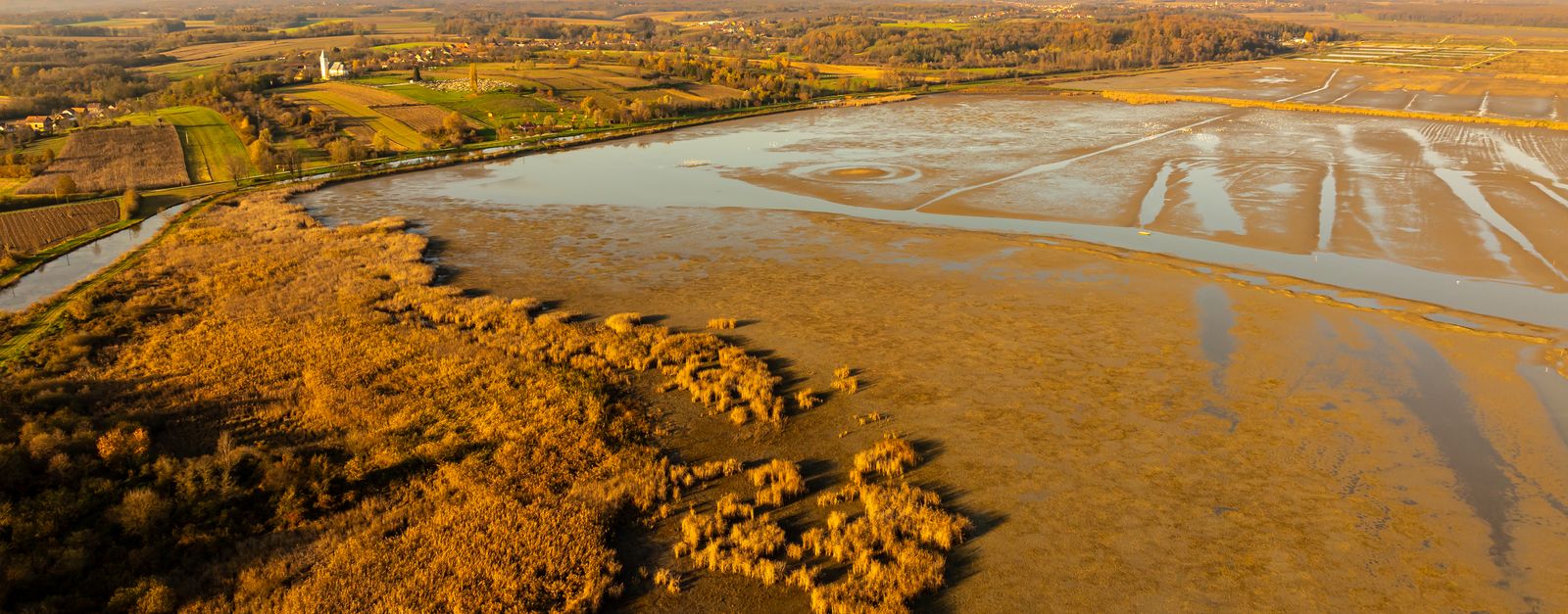 Stunning aerial vista of wetlands and countryside near Garešnica, Croatia, in warm autumn light.