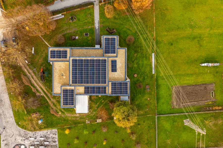 Aerial shot of a building with solar panels in a green landscape in Garešnica, Croatia.