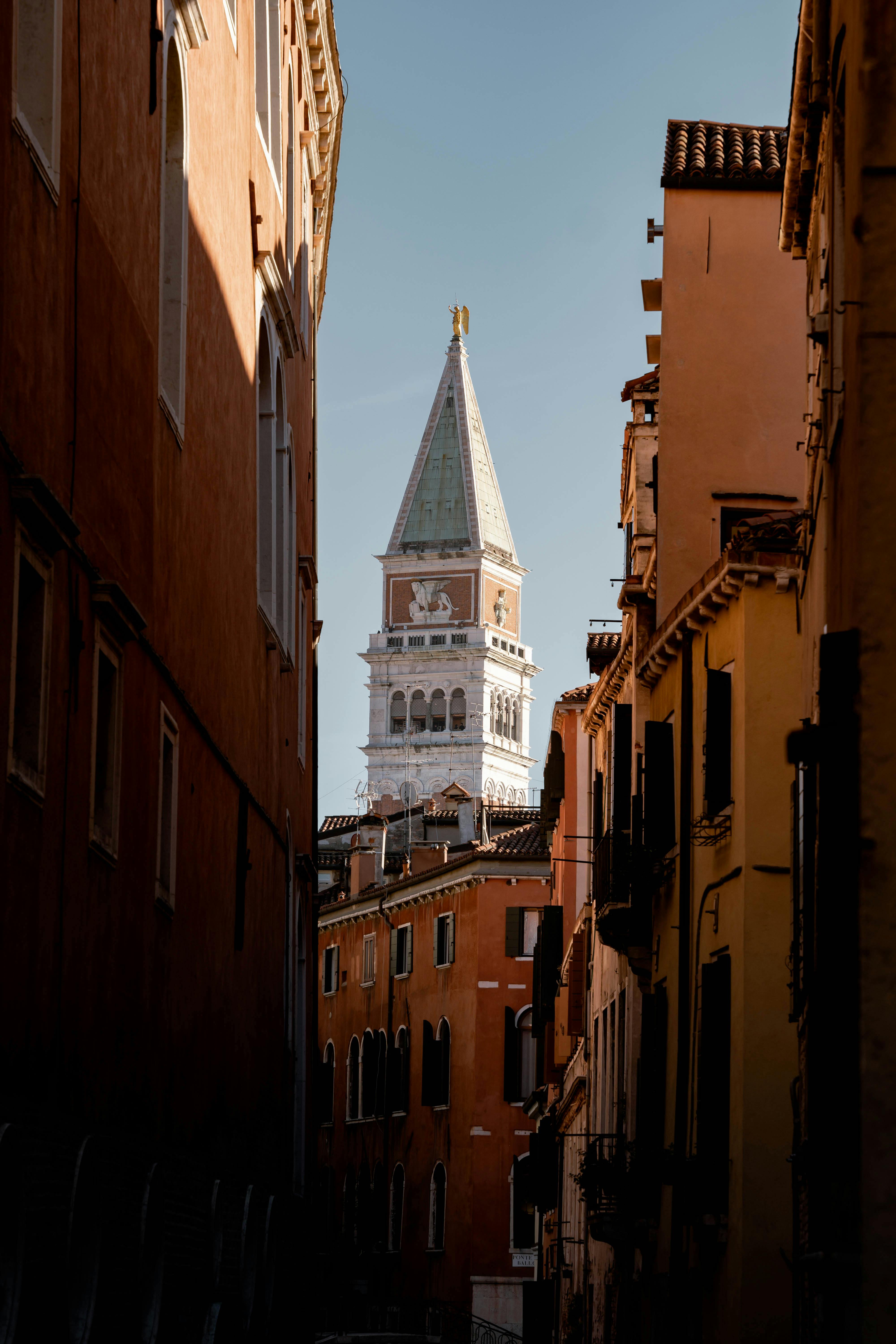 Captivating view of St Mark's Campanile from a narrow street in Venice, Italy.