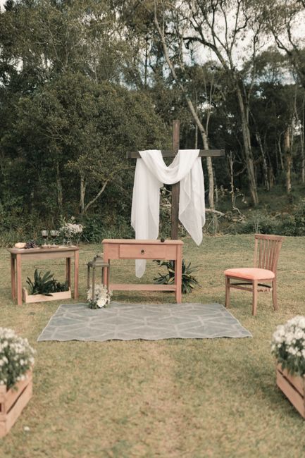 Fotomural Un altar rústico de boda al aire libre con cruz, mesa y silla en la naturaleza.