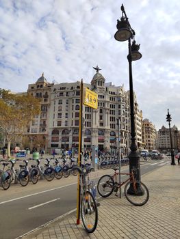 Street view of Valencia's iconic architecture with bicycle paths and classic street lamps.