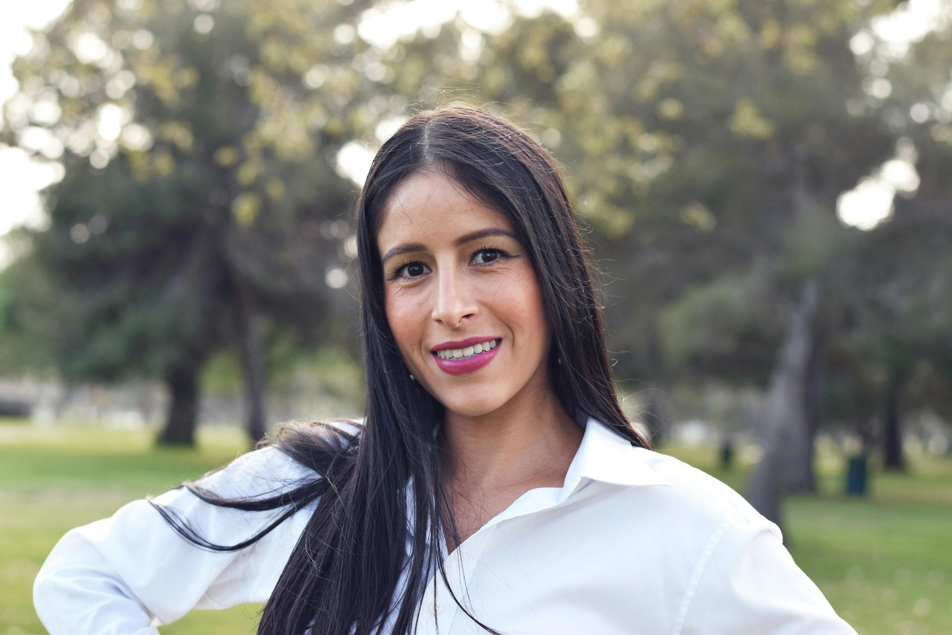 Portrait of a young woman smiling outdoors in Long Beach park.