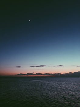 昆士兰州肖克利夫码头的日落景色很美，上方挂着一弯新月