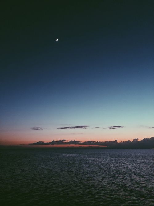 Free Beautiful sunset view at Shorncliffe Pier in Queensland with a crescent moon above. Stock Photo