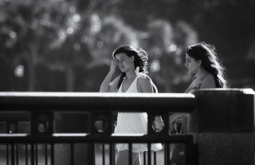 Free Two women walking together outdoors, enjoying a sunny day, capturing a candid moment in black and white. Stock Photo