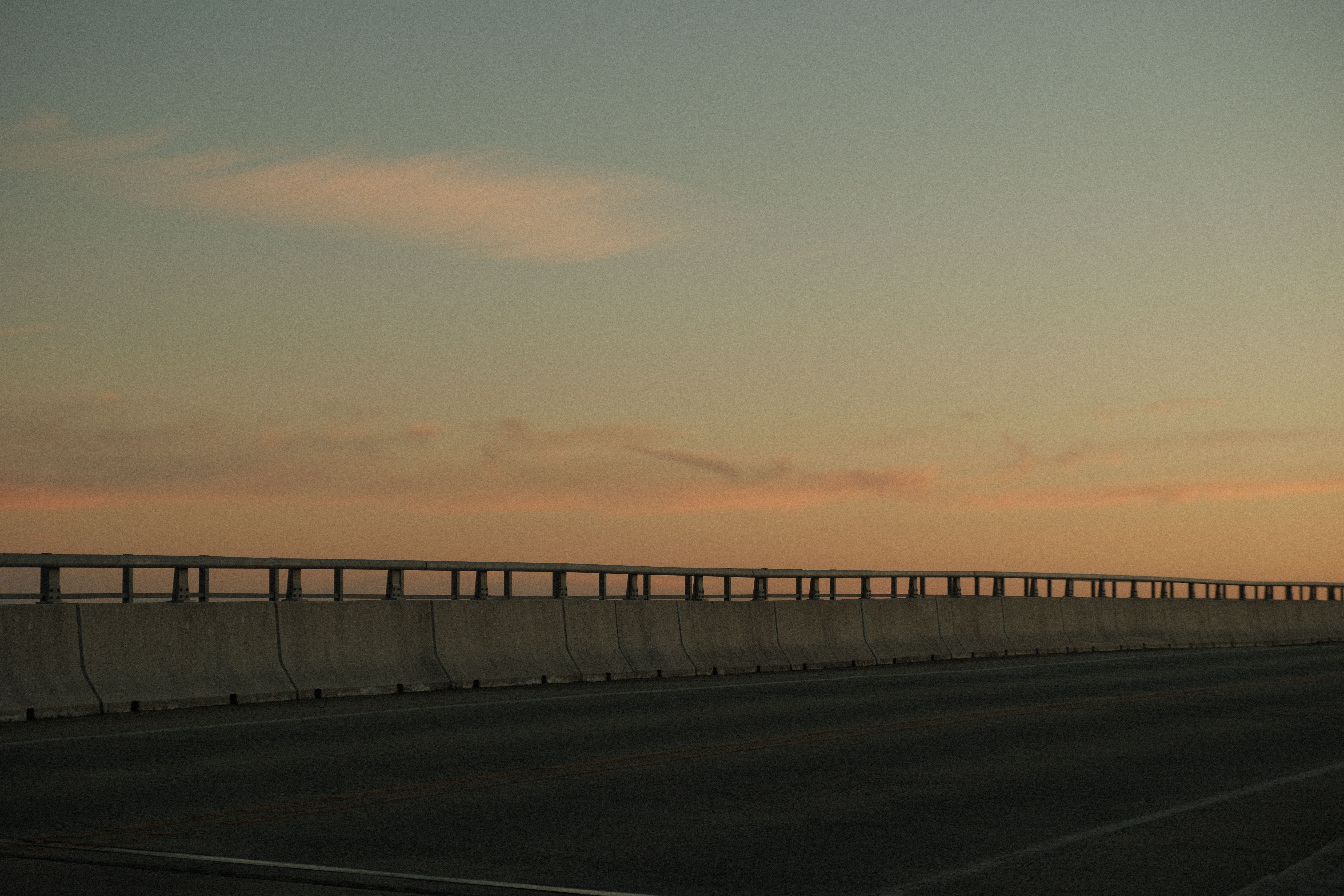 A peaceful evening view of an empty highway bridge against the dusk sky.