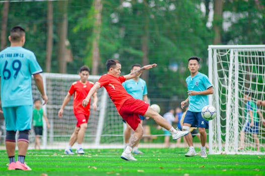 Dynamic soccer match captured outdoors on a green field in Hanoi, Vietnam.