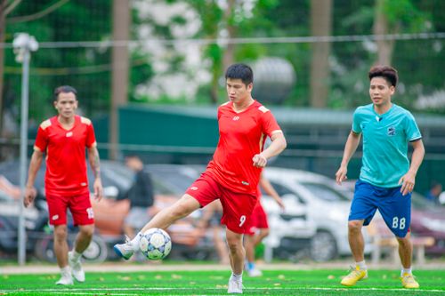 Free Three men playing an intense soccer match outdoors in Hanoi, Vietnam. Stock Photo