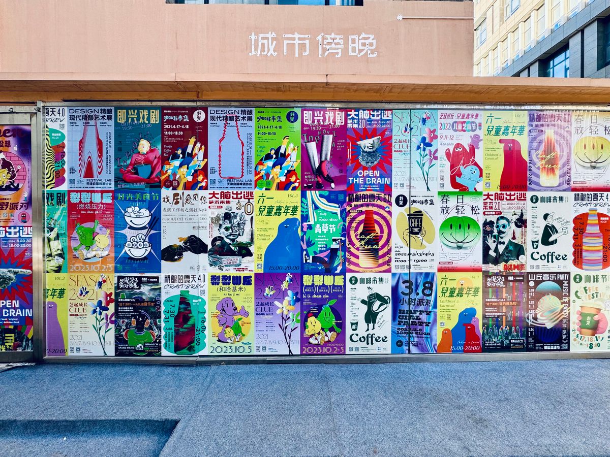 Street wall covered with dozens of colourful printed posters