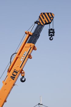 Close-up of ACE HY130 crane arm against clear sky in Faridabad, India.