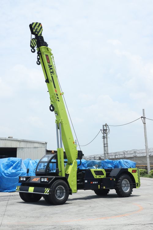Free A vibrant ACE TX 150 crane stands ready in a Faridabad industrial yard under a bright sky. Stock Photo