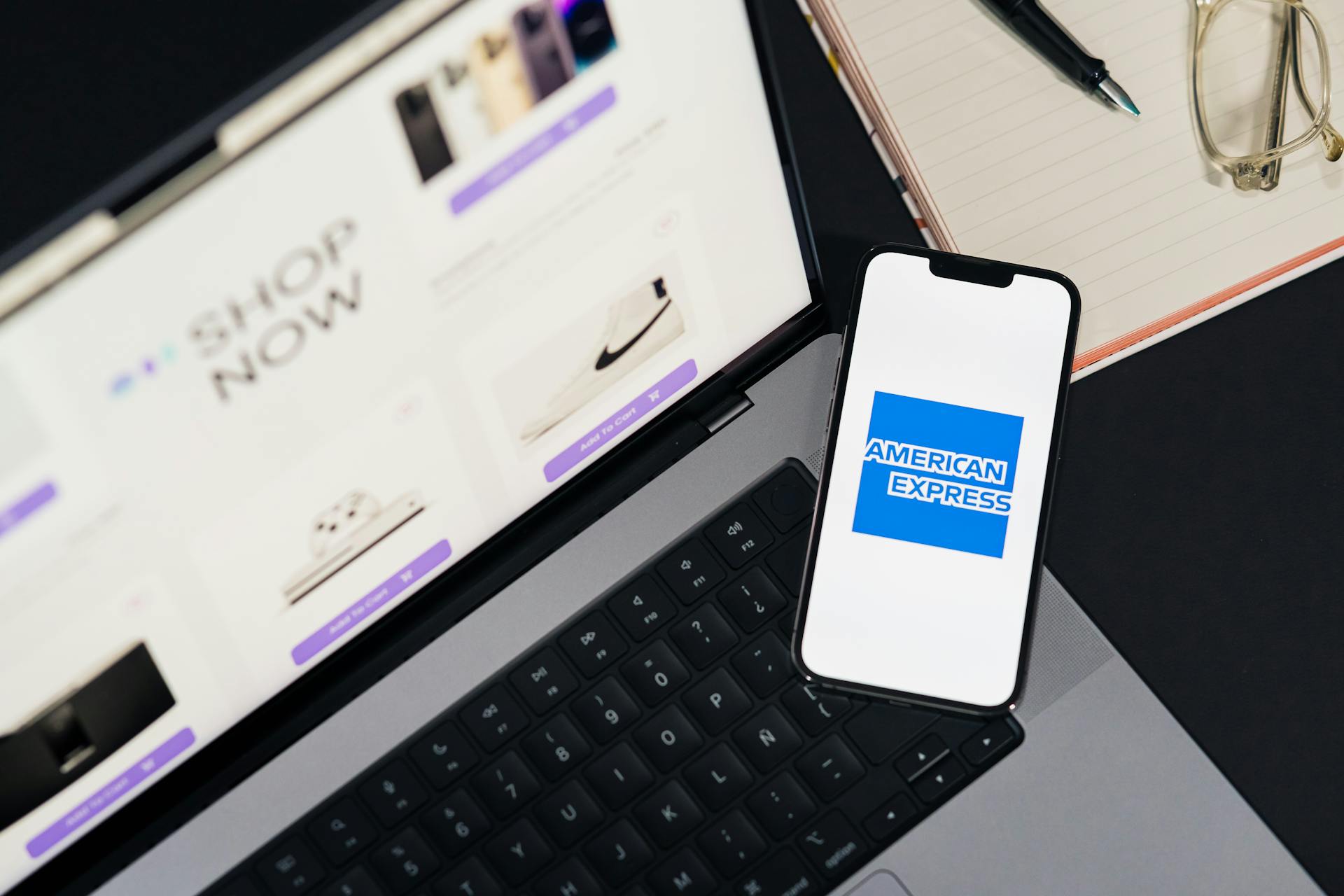 Smartphone displaying American Express logo on a laptop for online shopping convenience.