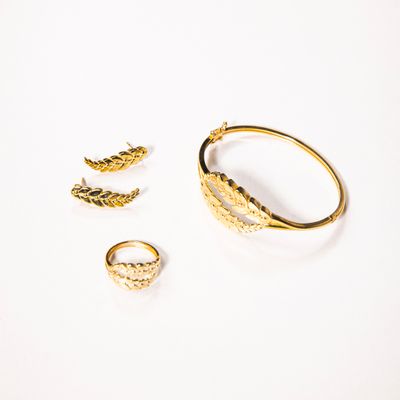 Gold leaf-pattern bangle, ring and ear climbers on white, photo by Yusuf Celik on Pexels