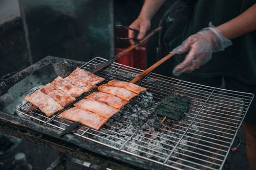 Free Outdoor barbecue scene with skewered grilled food over charcoal grill. Stock Photo