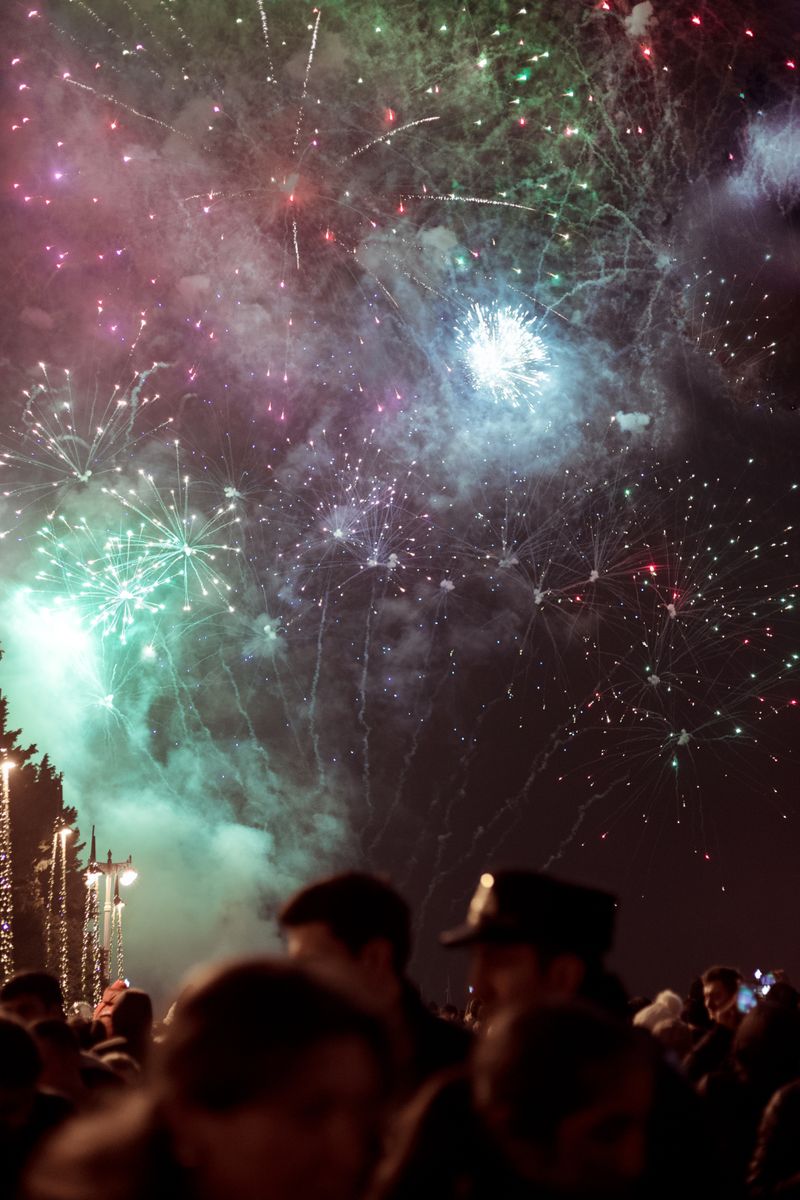 Colourful fireworks lighting up the night sky over a festa crowd