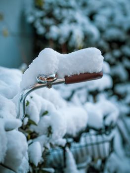 Close-up of a snow-laden bicycle handlebar in Munich, capturing winter's serene stillness.