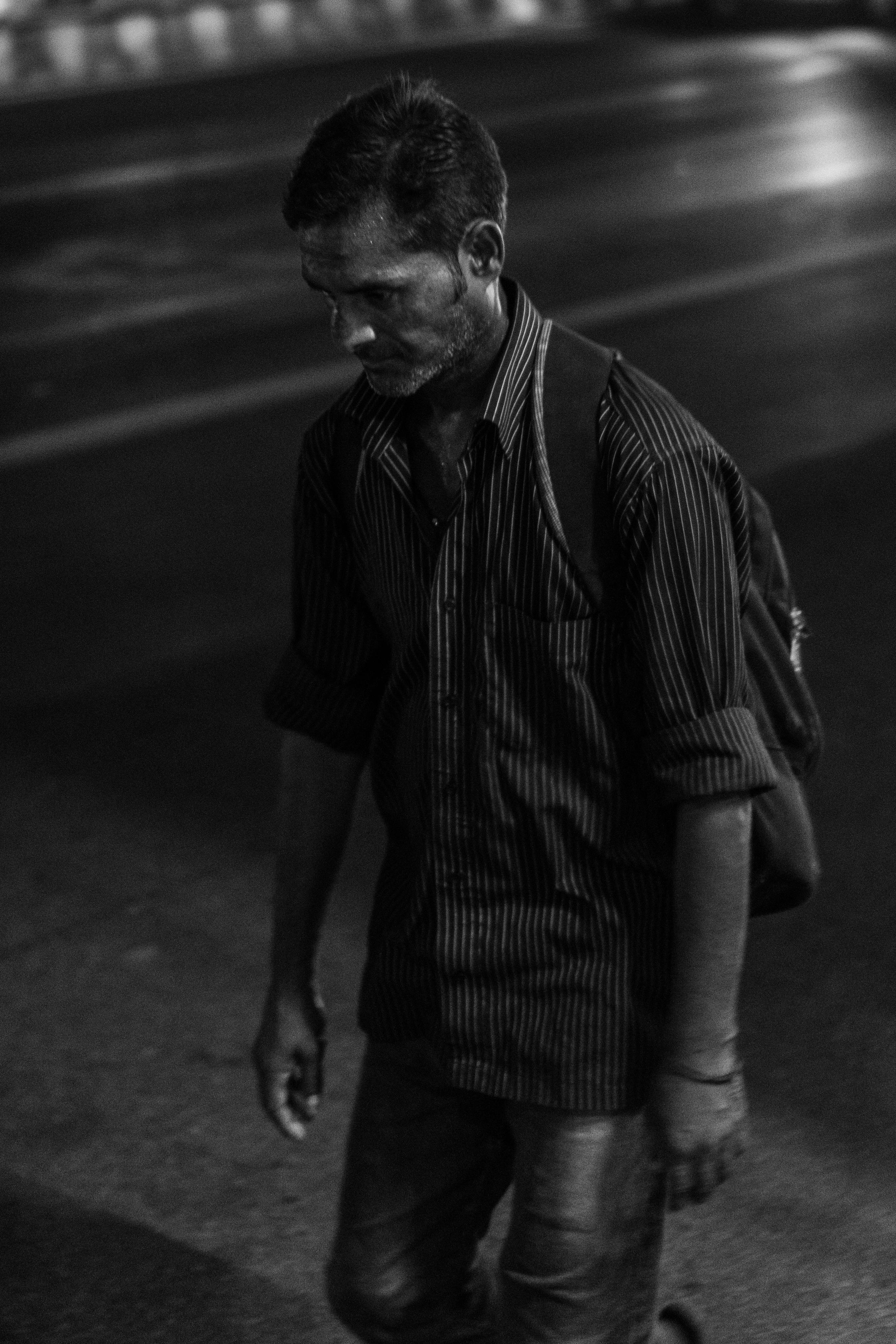 一张男人夜晚独自走在街上的单色图像