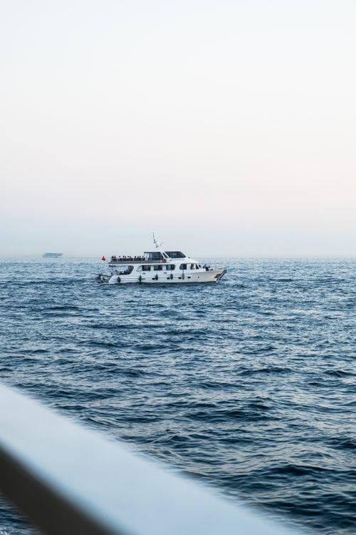 Free A peaceful yacht sails through the Bosphorus in Istanbul during a serene sunrise. Stock Photo