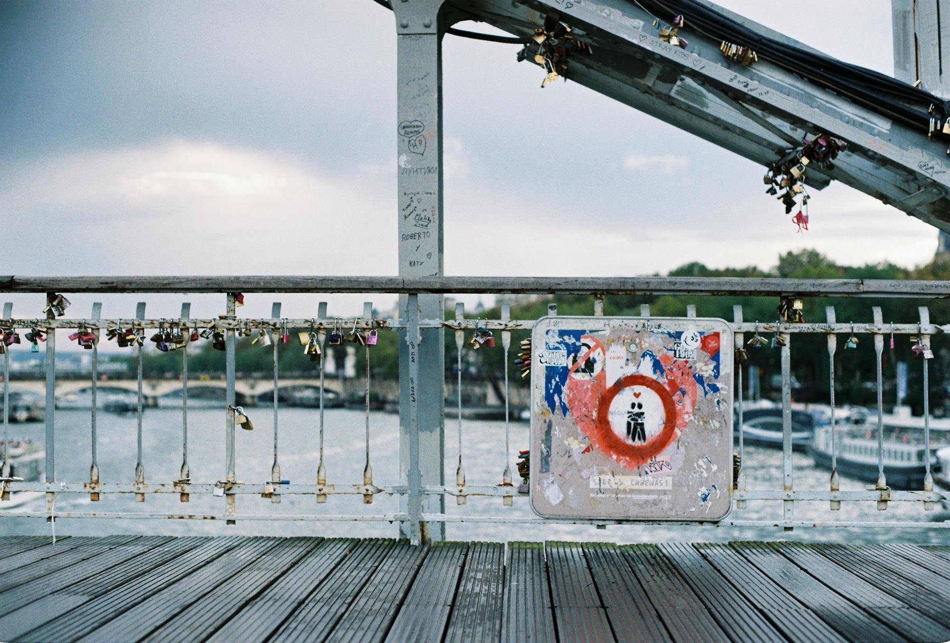 Romantic view of a bridge in Paris adorned with love locks against a serene river background.