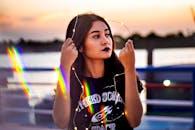 一位手持童话灯的年轻女子，以充满彩虹效果的活力日落为背景的肖像