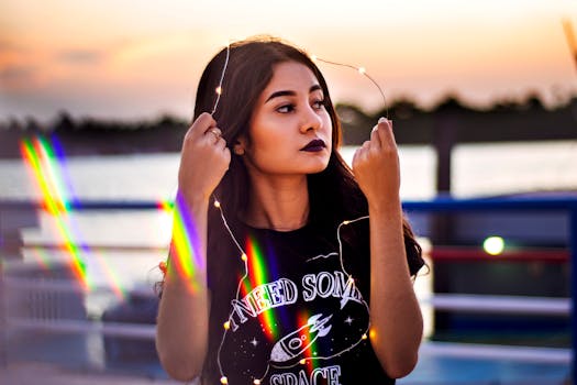 一位手持童话灯的年轻女子，以充满彩虹效果的活力日落为背景的肖像