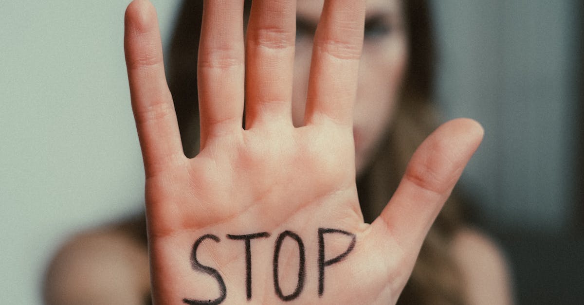 Close-up of a woman's hand with 'Stop' written on it, emphasizing awareness.