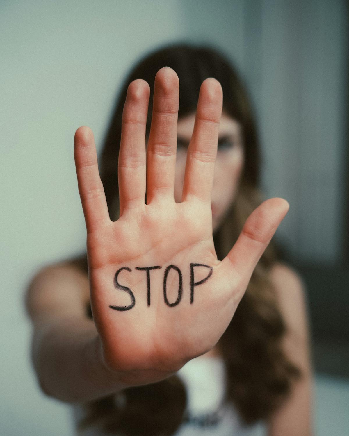 Photography of a Persons Hand With Stop Signage · Free Stock Photo