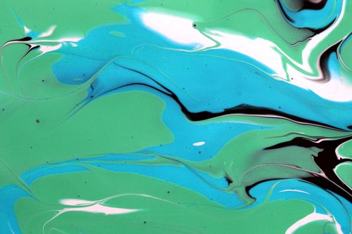 Free Vibrant abstract fluid art with swirling green, blue, and black patterns. Stock Photo
