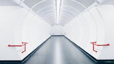 这条现代地下隧道采用白色设计，配有红色扶手和未来派风格