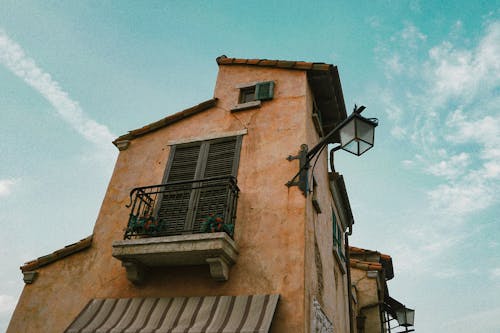 Low Angle Photography Of A Narrow Brown House